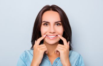 smiling woman pointing at her teeth