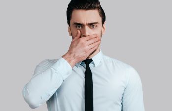 man covering his mouth because of bath breath