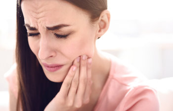 woman touching her mouth because of a toothache